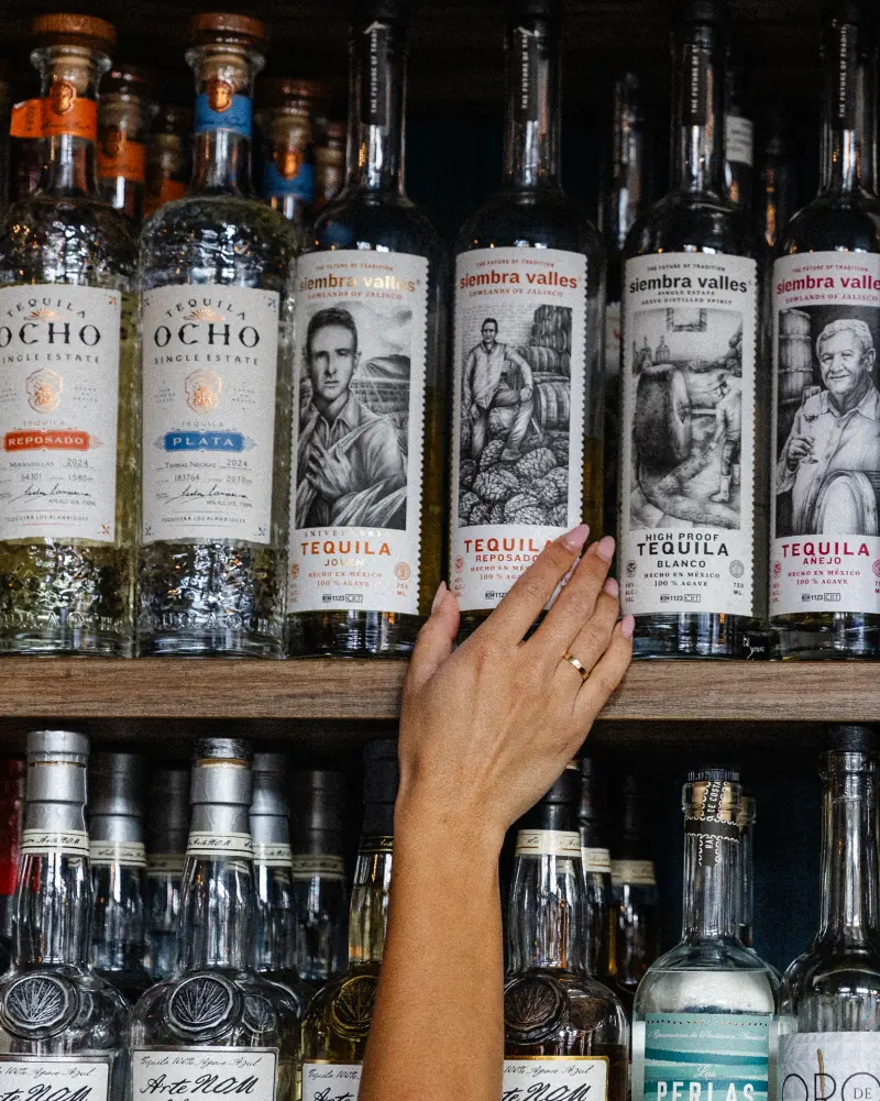 Reaching for a bottle on the agave shelf