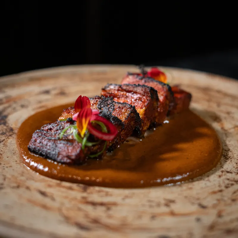 Mole with seared meat and a flower garnish