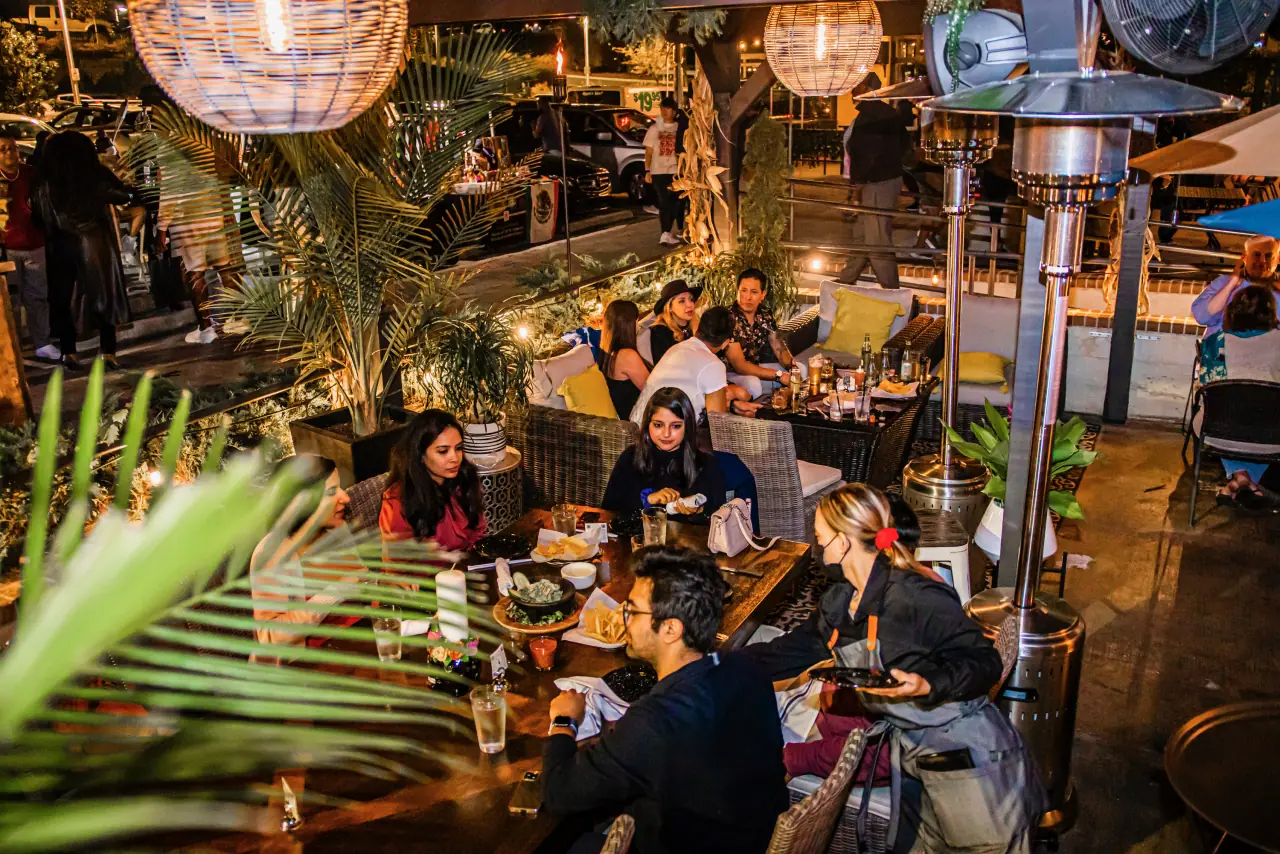 The patio at night, full of guests under lanterns