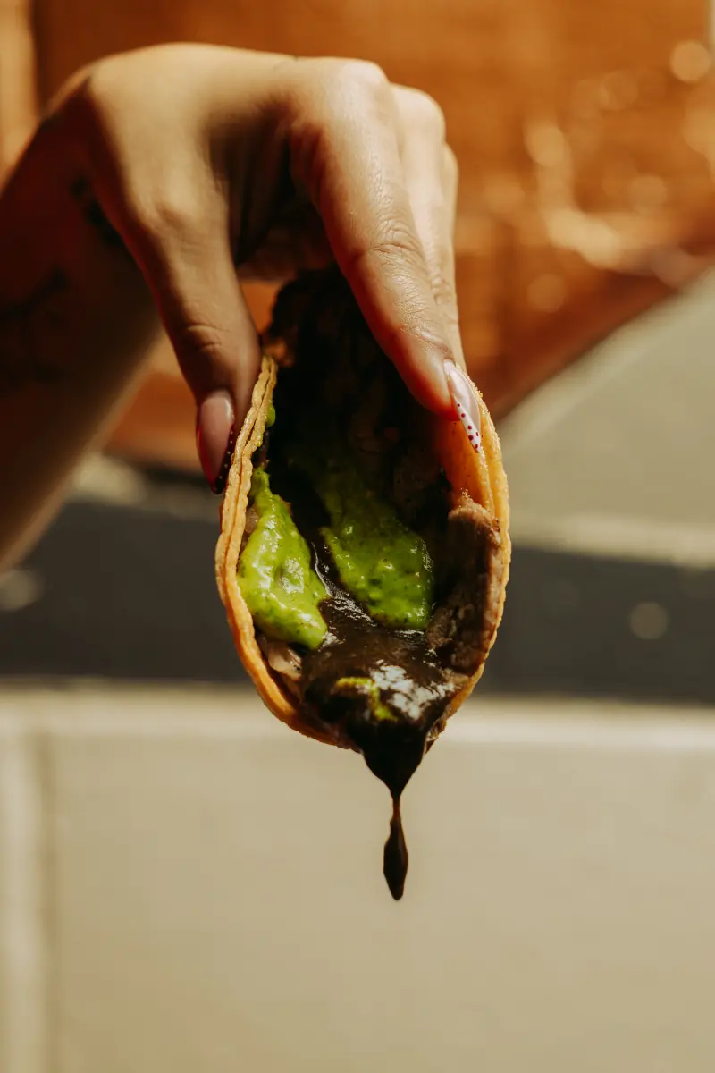 A taco dipped in sauce